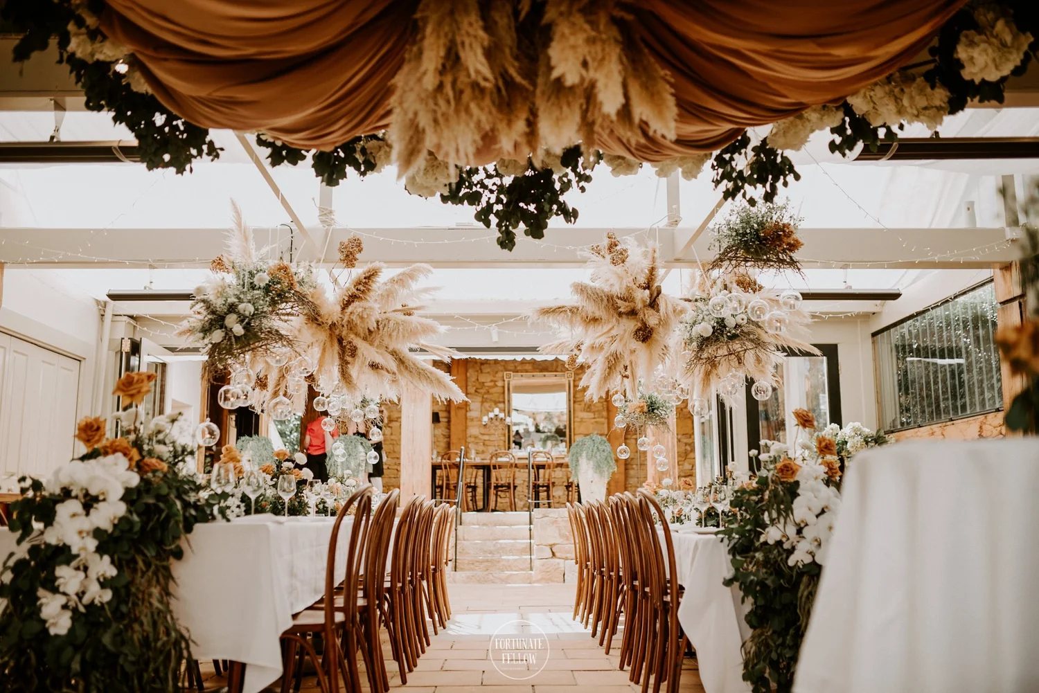 A reception styled with pampas grass and dried flowers over long tables